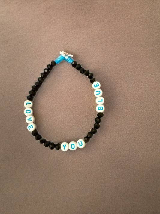 Black beaded bracelet with white and blue “LOVE YOU BLUE” letter beads and blue ribbon.