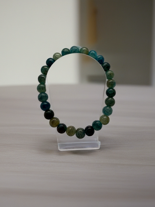 Beaded bracelet on a clear stand with a neutral background