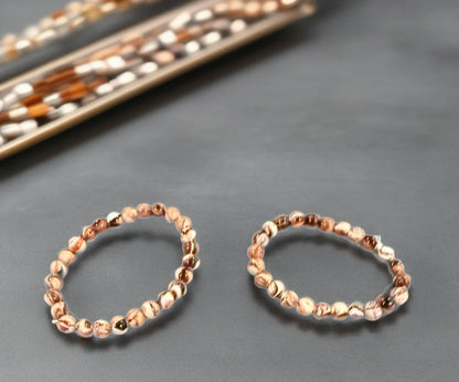 Two beaded bracelets on a gray surface