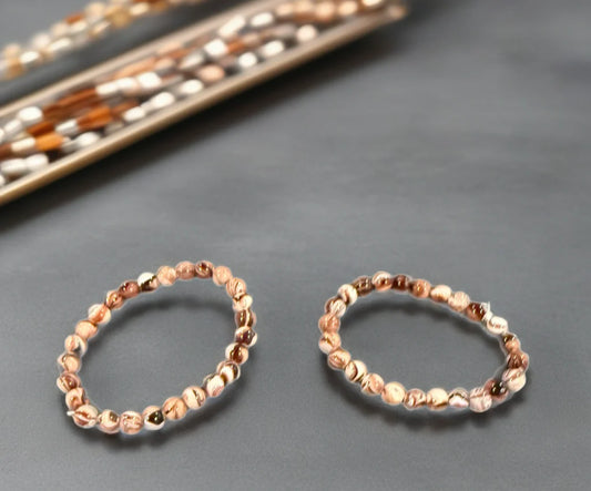 Two beaded bracelets on a gray surface